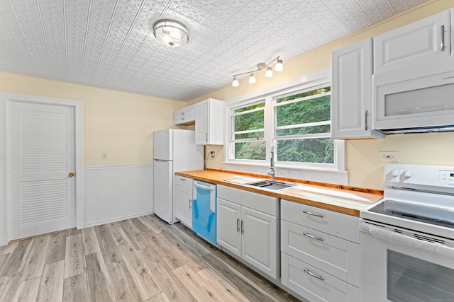 kitchen featuring white cabinets, white appliances, light wood-type flooring, wood counters, and sink