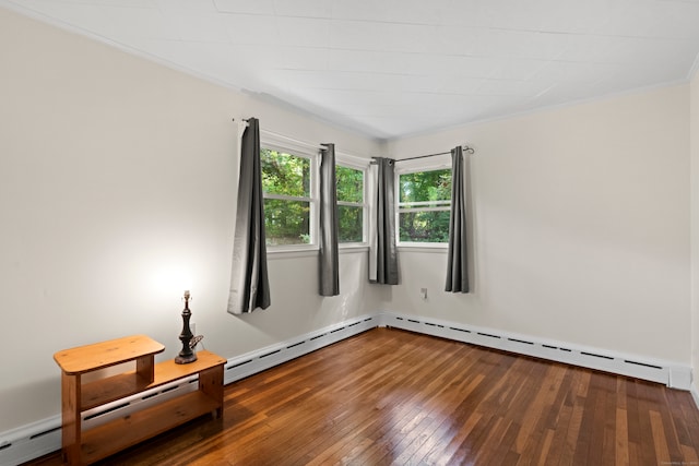 empty room with ornamental molding, hardwood / wood-style floors, and a baseboard heating unit