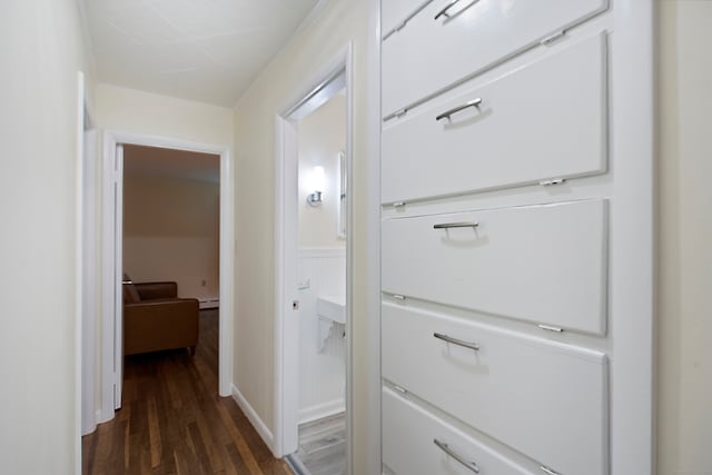 hallway with a baseboard heating unit and dark hardwood / wood-style floors