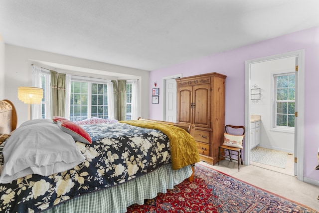 bedroom with ensuite bath and multiple windows