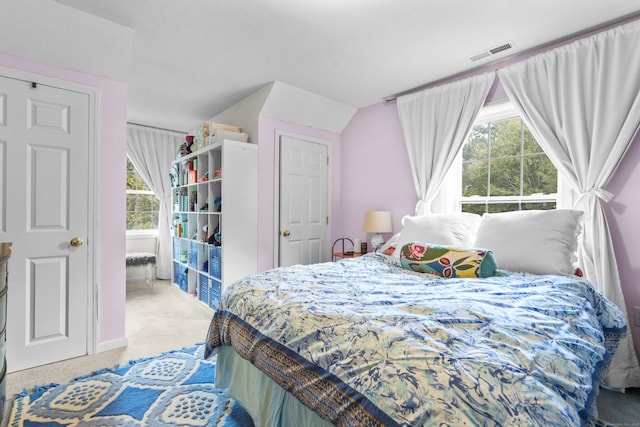 bedroom with light colored carpet and vaulted ceiling