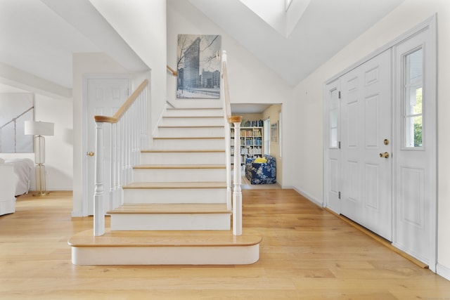 foyer with light hardwood / wood-style flooring and lofted ceiling