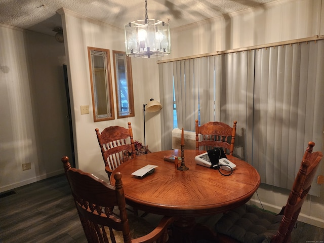 dining space with a notable chandelier, a textured ceiling, and dark hardwood / wood-style floors