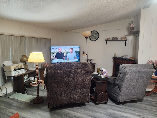 living room featuring a textured ceiling, lofted ceiling, and hardwood / wood-style flooring