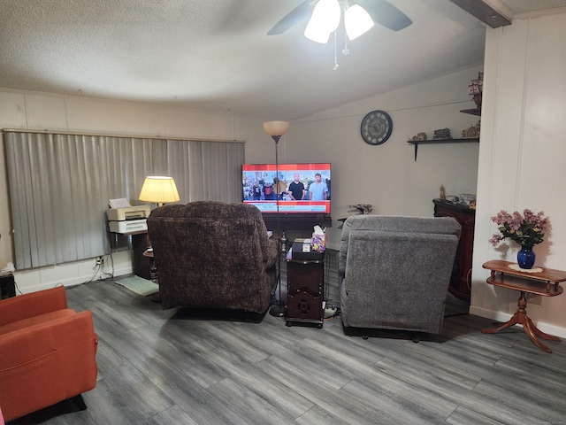 living room featuring ceiling fan, hardwood / wood-style flooring, vaulted ceiling, and a textured ceiling