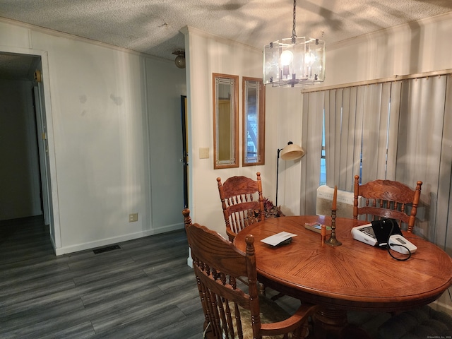 dining space with a chandelier, a textured ceiling, and dark hardwood / wood-style floors