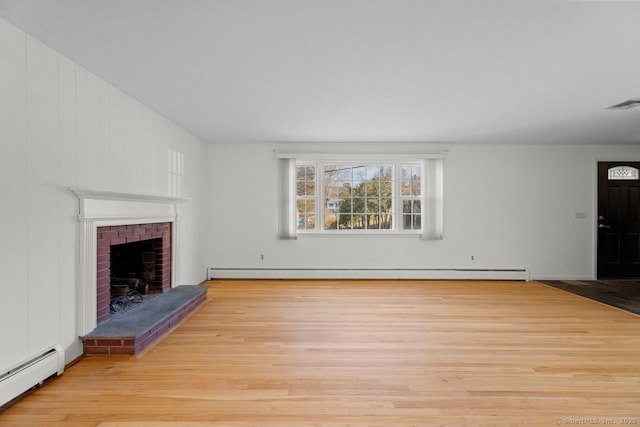 unfurnished living room with a baseboard radiator, a fireplace, and light hardwood / wood-style floors