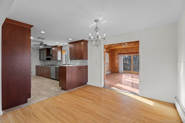 kitchen featuring sink, tasteful backsplash, light hardwood / wood-style flooring, baseboard heating, and ceiling fan with notable chandelier