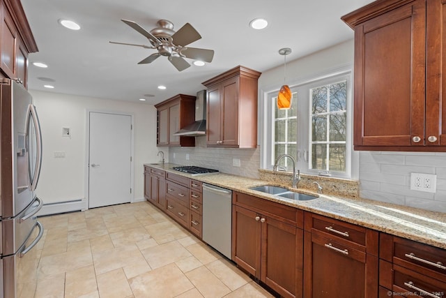 kitchen with pendant lighting, wall chimney range hood, sink, a baseboard heating unit, and stainless steel appliances