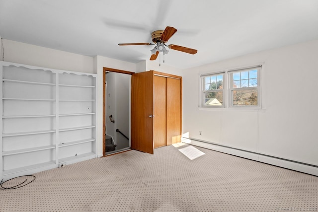 unfurnished bedroom with baseboard heating, ceiling fan, carpet flooring, and a closet