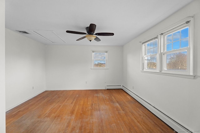 unfurnished room with a baseboard radiator, a wealth of natural light, and light hardwood / wood-style floors