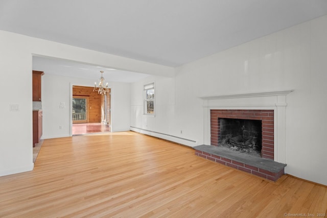 unfurnished living room featuring a brick fireplace, a baseboard radiator, light hardwood / wood-style floors, and a chandelier