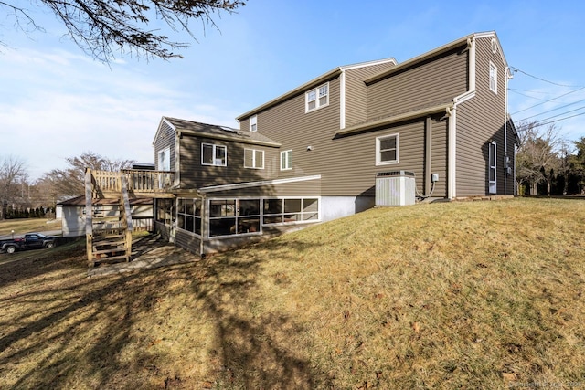 rear view of house with a wooden deck, a sunroom, a yard, and central air condition unit