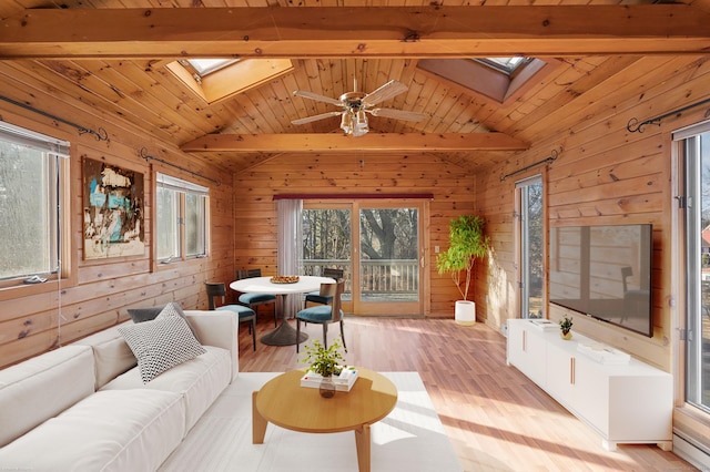 living room with wood ceiling, a healthy amount of sunlight, lofted ceiling with skylight, and light wood-type flooring