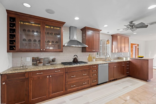 kitchen featuring stainless steel appliances, sink, wall chimney range hood, and decorative backsplash