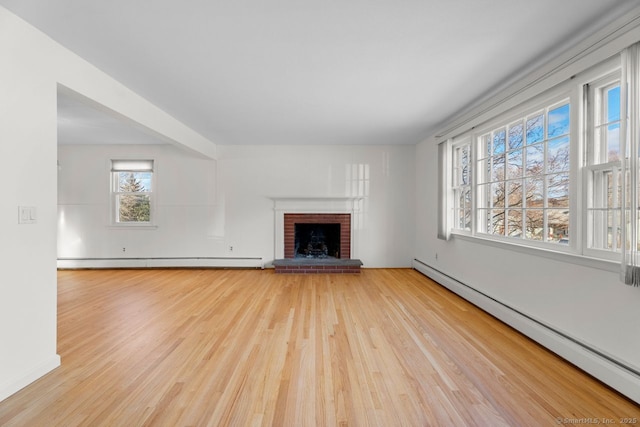 unfurnished living room with a fireplace, a baseboard radiator, and light hardwood / wood-style floors