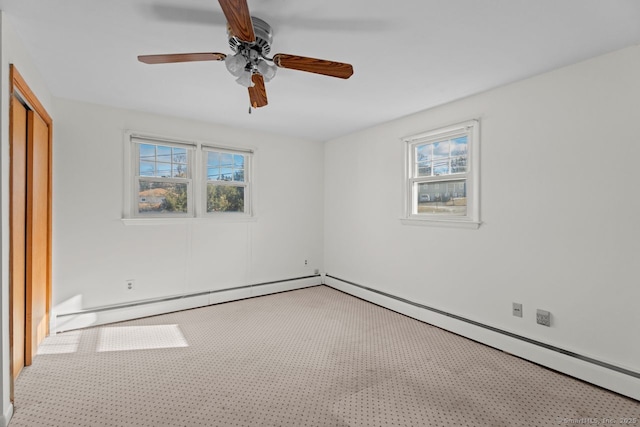 unfurnished bedroom with baseboard heating, ceiling fan, a closet, and carpet