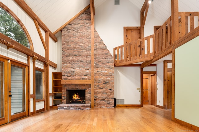 unfurnished living room with a fireplace, hardwood / wood-style floors, high vaulted ceiling, and wooden ceiling