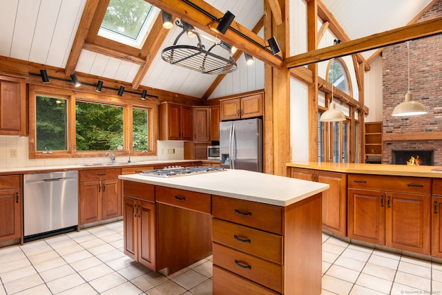 kitchen featuring decorative light fixtures, stainless steel appliances, high vaulted ceiling, and a center island