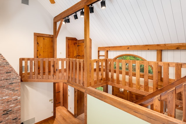 corridor featuring light wood-type flooring, beamed ceiling, track lighting, high vaulted ceiling, and wooden ceiling