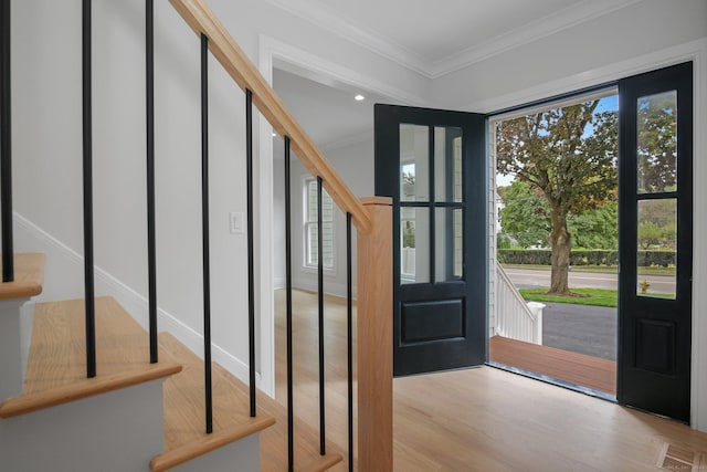 foyer entrance with crown molding and light wood-type flooring