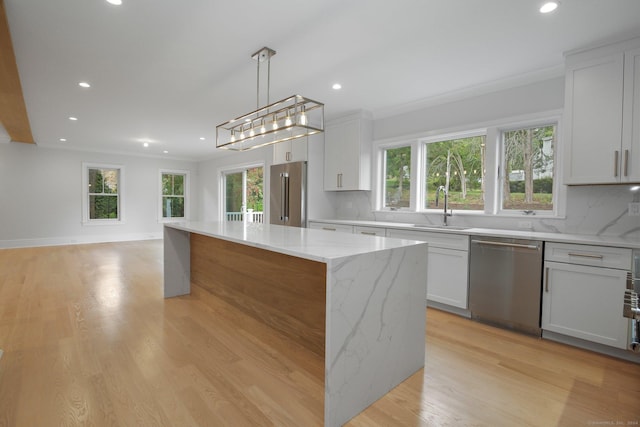 kitchen with white cabinetry, a center island, backsplash, decorative light fixtures, and appliances with stainless steel finishes