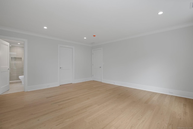 spare room featuring light wood-type flooring and ornamental molding