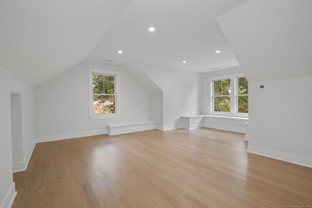 bonus room featuring light hardwood / wood-style floors, vaulted ceiling, and a wealth of natural light