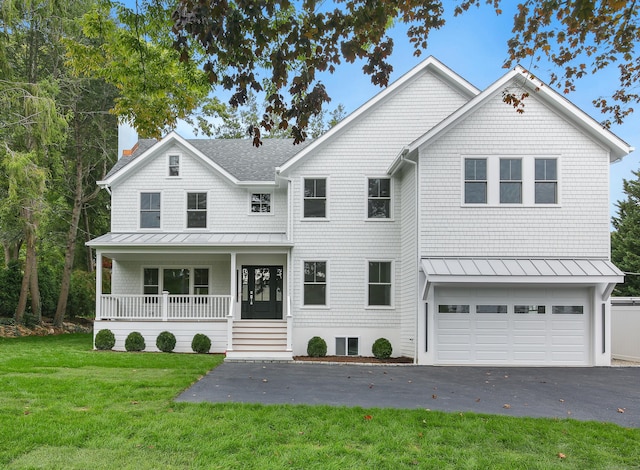 view of front of home with covered porch, a front yard, and a garage