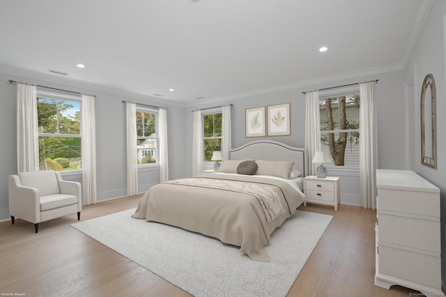 bedroom with light hardwood / wood-style flooring, crown molding, and multiple windows