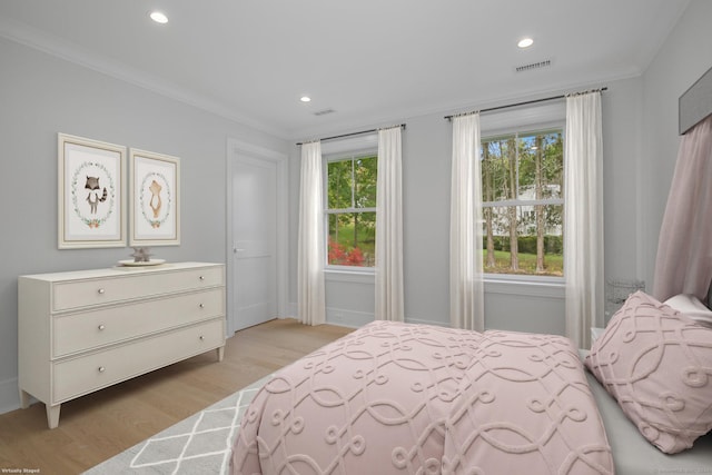 bedroom with light wood-type flooring and crown molding