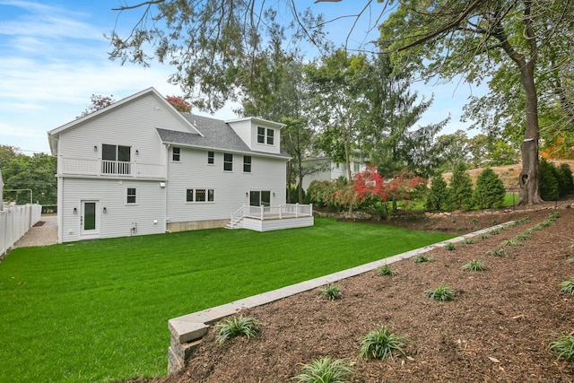 rear view of property featuring a lawn and a wooden deck