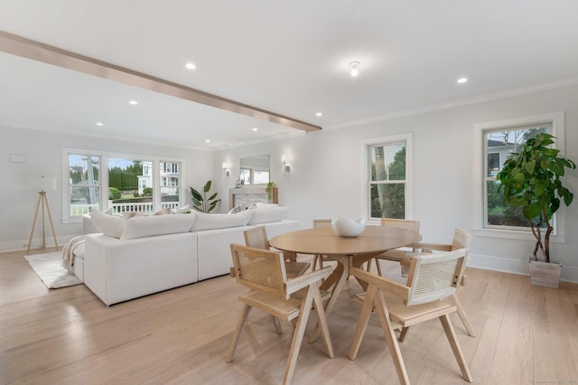 dining space with light hardwood / wood-style floors and crown molding