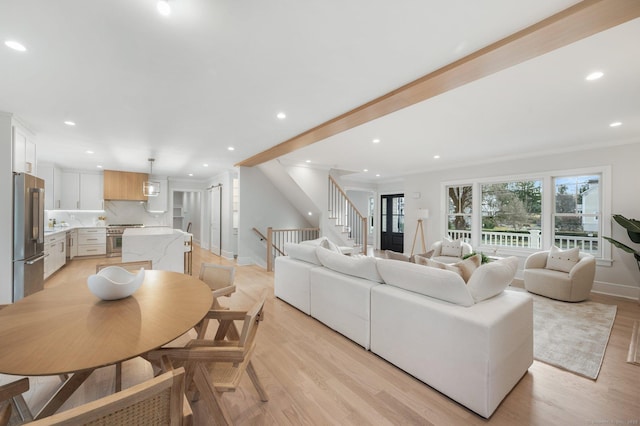 living room with crown molding and light wood-type flooring