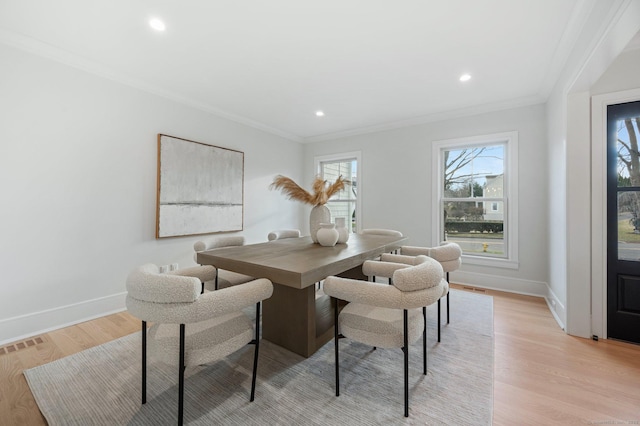 dining room featuring ornamental molding and light hardwood / wood-style flooring