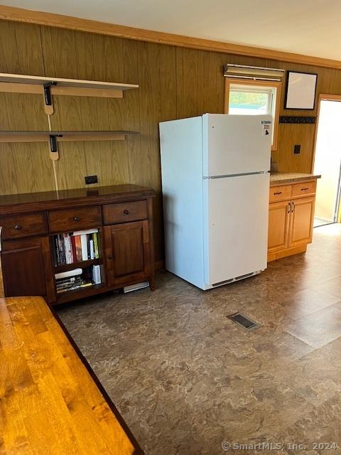 kitchen featuring wood walls and white fridge