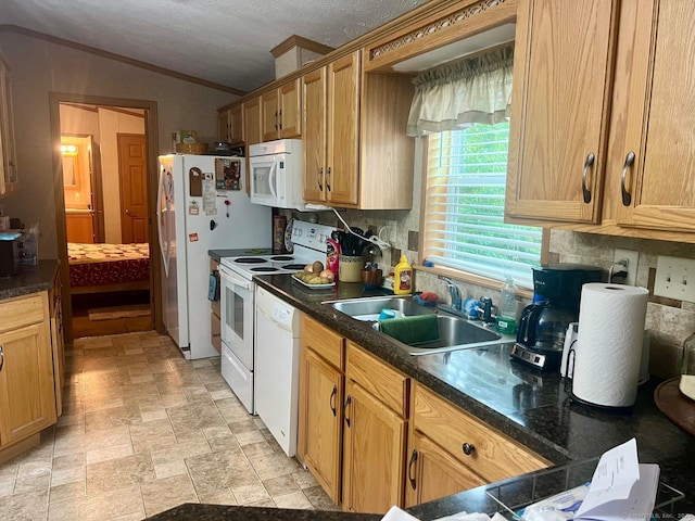 kitchen with dark countertops, a sink, white appliances, decorative backsplash, and vaulted ceiling