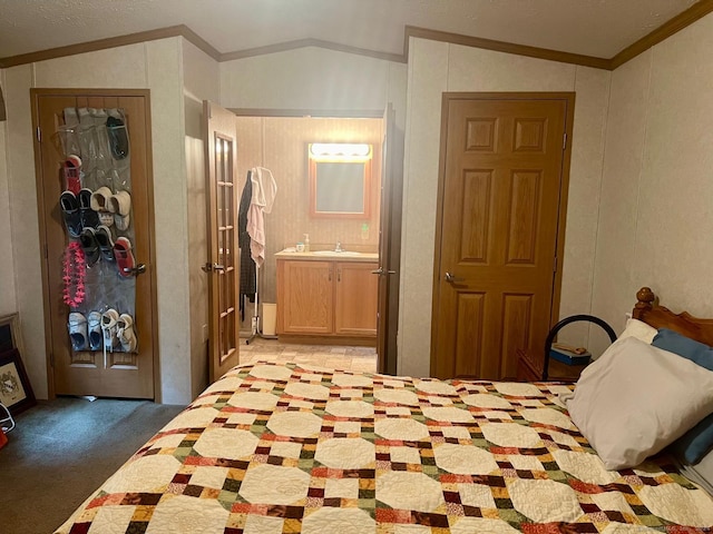 bedroom with crown molding, vaulted ceiling, light carpet, and a sink