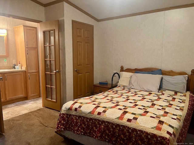 bedroom with ensuite bath, ornamental molding, and light carpet