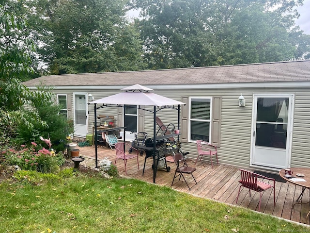 rear view of property with a gazebo, a wooden deck, and roof with shingles