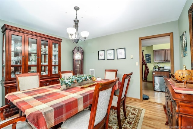 dining space featuring light hardwood / wood-style floors and a chandelier