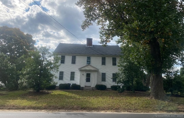 colonial house featuring a front lawn