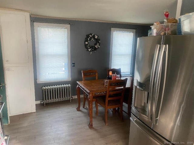 dining area featuring radiator heating unit and light hardwood / wood-style flooring