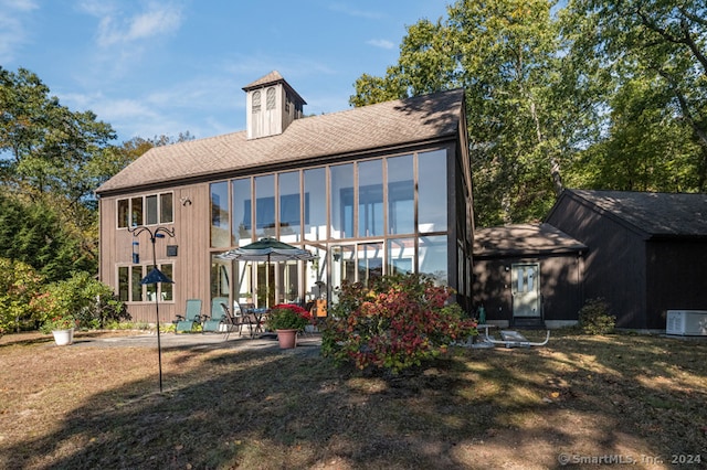 rear view of house with a patio and a yard