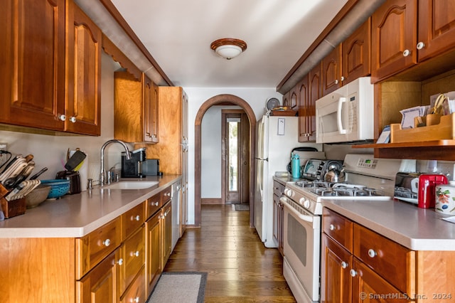 kitchen featuring dark wood-type flooring, sink, and white appliances