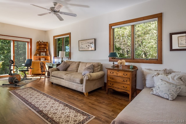 living room with dark wood-type flooring, plenty of natural light, and ceiling fan