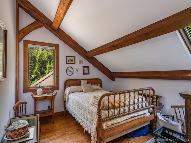 bedroom featuring light wood-type flooring and lofted ceiling with beams