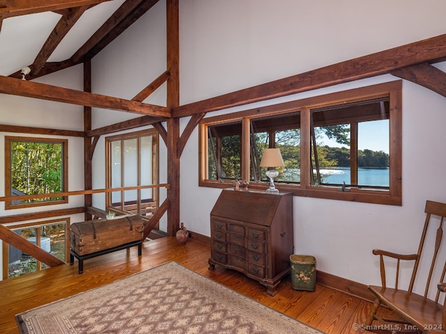 living area with wood-type flooring, a water view, and a healthy amount of sunlight