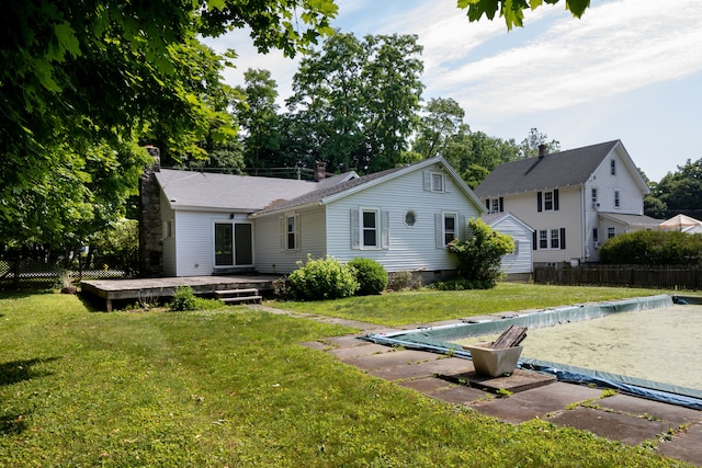 back of property featuring a lawn and a pool side deck