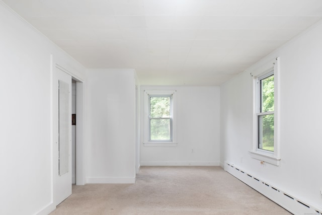 carpeted spare room featuring crown molding and a baseboard radiator